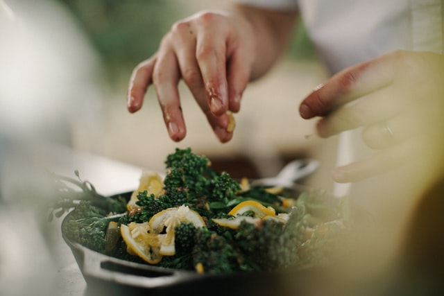 Image of hands preparing salad with selective focus